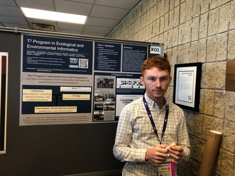 Male grad student in front of poster