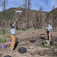 Two scientists test a drone in the field